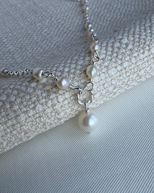 Close-up of Amélie pearl necklace with delicate rice pearl spacing and central pearl drop in gold filled or sterling silver