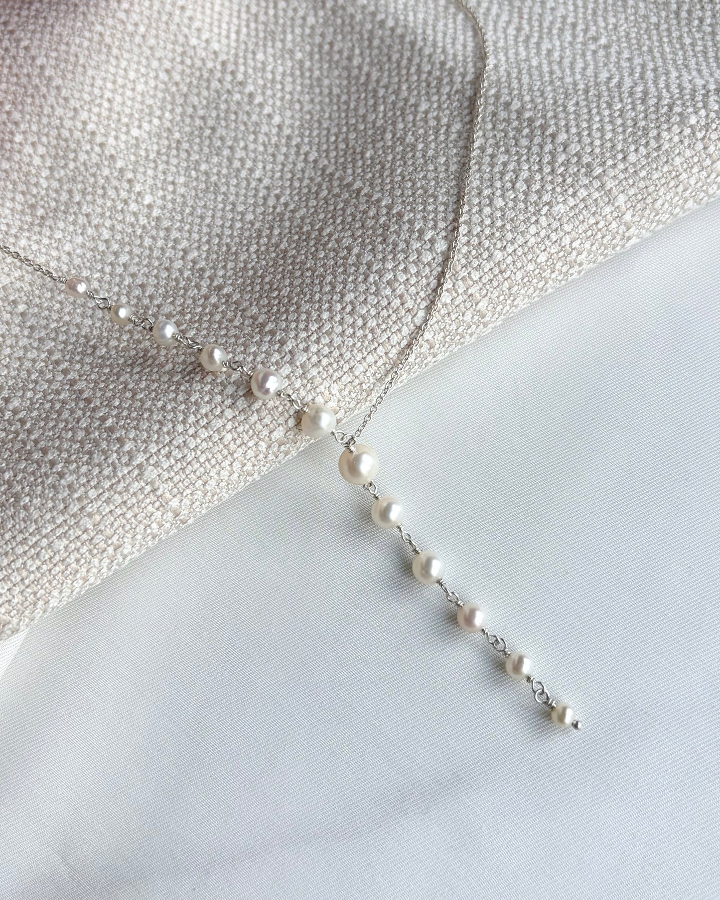 Sculptural Y-shaped necklace featuring graduated freshwater pearls with a soft cascading drop