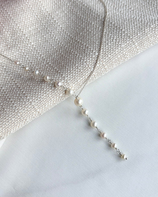 Sculptural Y-shaped necklace featuring graduated freshwater pearls with a soft cascading drop